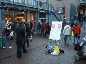 Campagne D66 in de Marikenstraat met een stelling op een flip-overbord tussen het winkelend publiek.