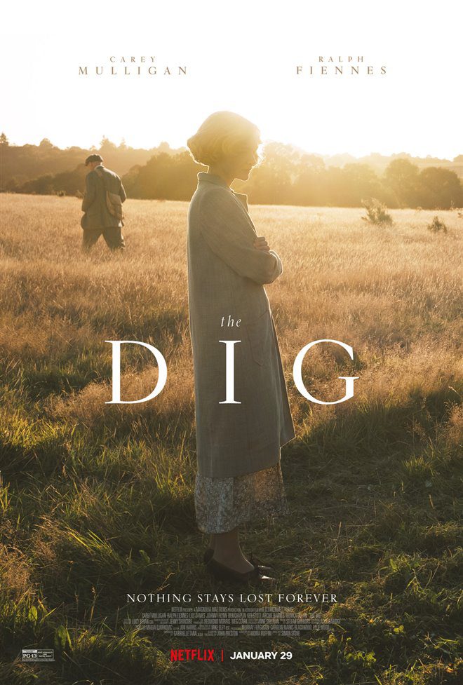 Filmposter van The Dig: een vrouw staat wat mistroostig in een veld naar de grond te kijken, op de achtergrond loopt een man weg en dat in een laagstaand zonnetje.