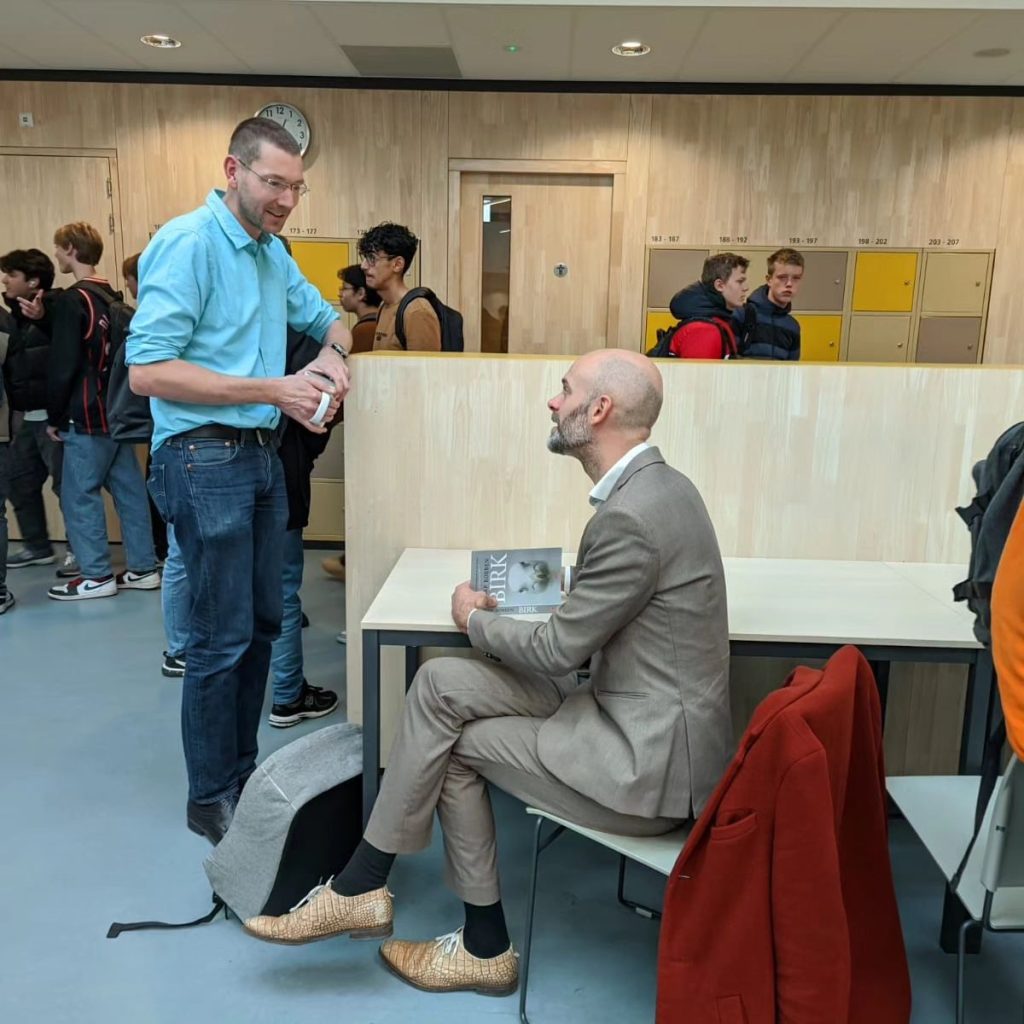 Jaap Robben signeert een boek voor Wim Pelgrim.